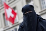 Warum sie zur Osterzeit Eier essen soll, ist ihr schleierhaft: grauenhaft plakativ fotografierte Muslima vor einer Schweizer Flagge. Bild: KEYSTONE